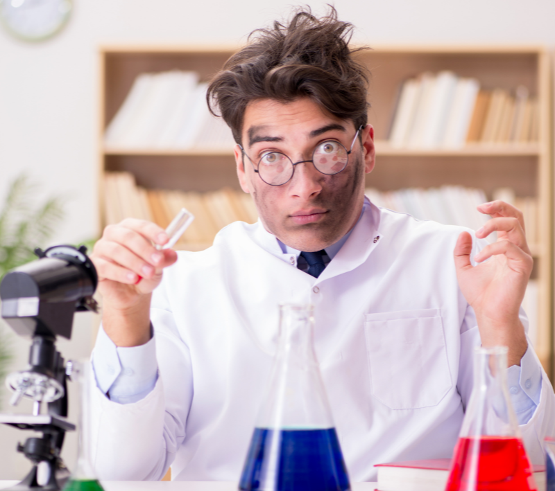 A scientist with test tubes and black marks on his face.